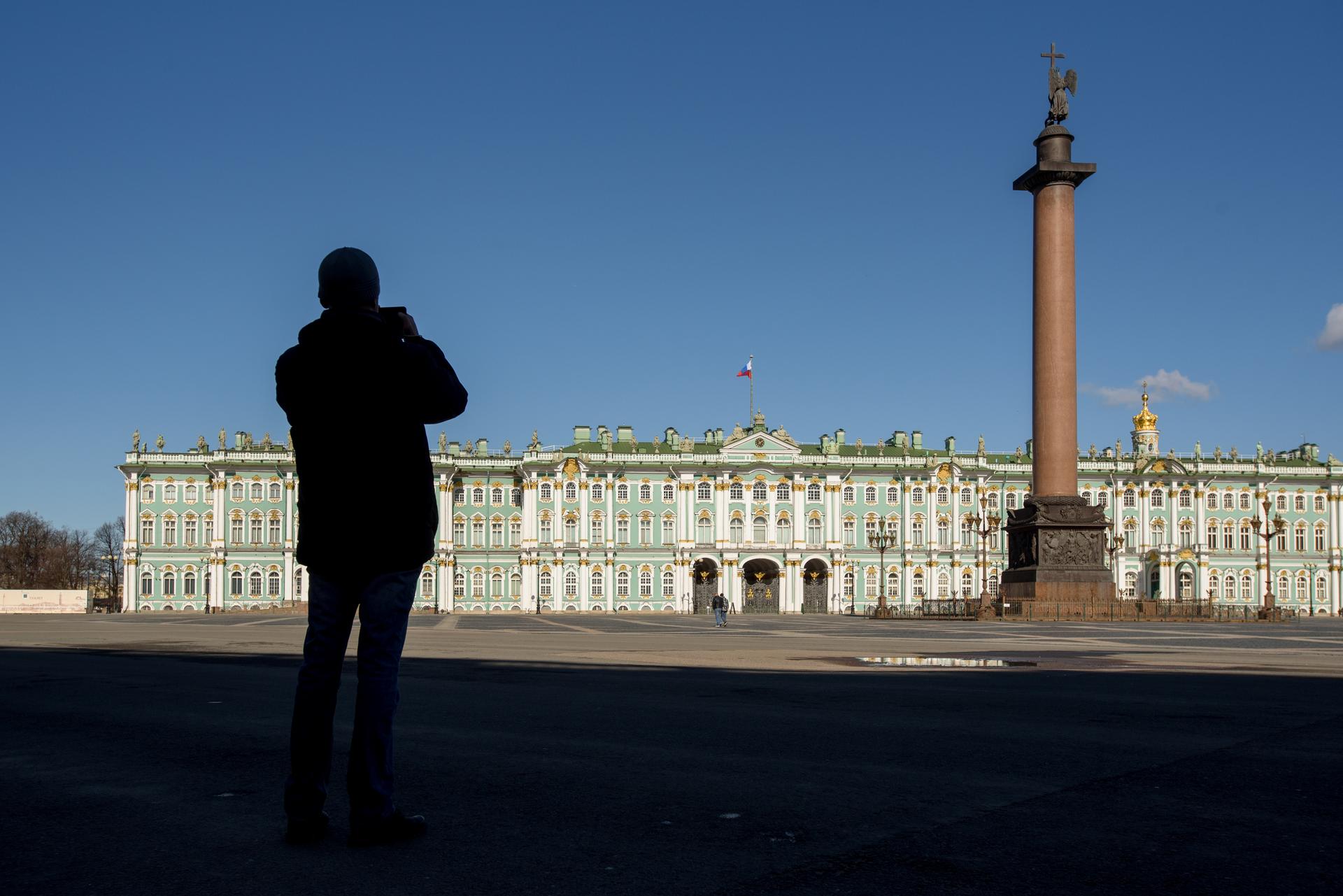 Открытие Эрмитажа для посетителей. Санкт-Петербург в апреле. В Петербурге посетителей Эрмитажа. Фото человека на фоне Эрмитажа.