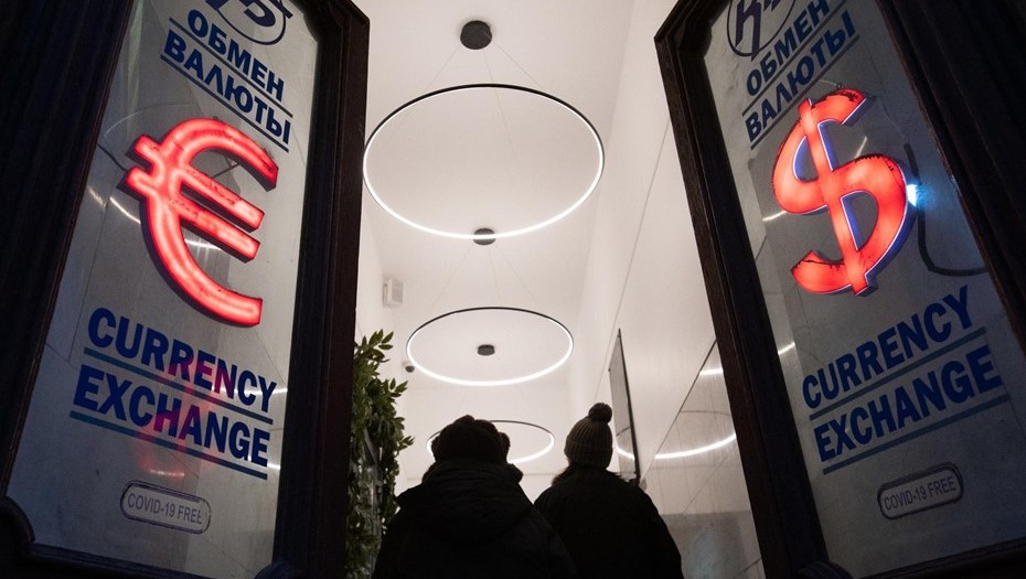 Прохожие рядом с пунктом обмена валют в центре Санкт-Петербурга.