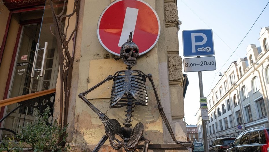 Фасад дома у входа в петербургский бар украшен металлической скульптурой человеческого скелета. 