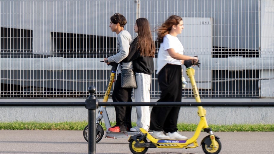 Молодые люди катаются на электросамокатах.
