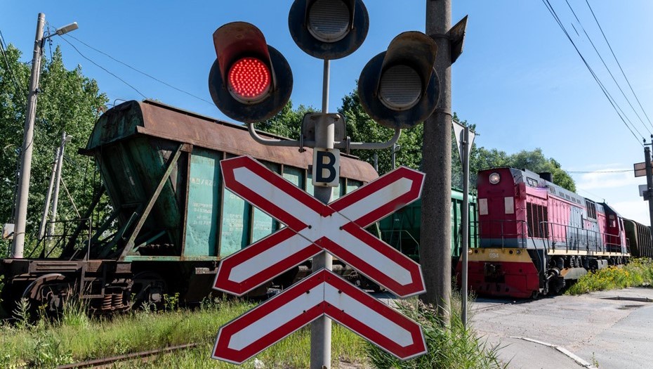 Грузовые составы на железнодорожном переезде.