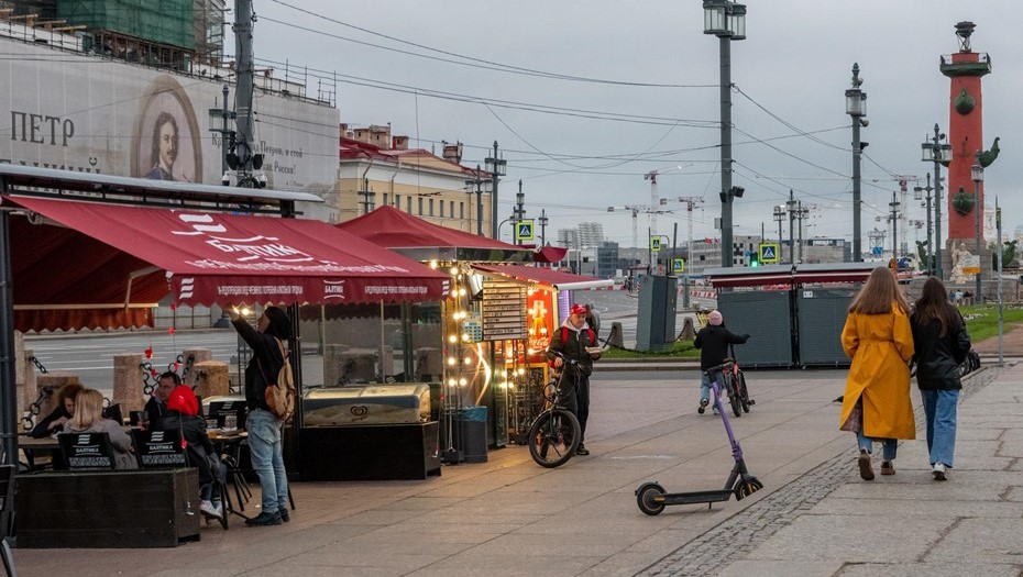 Белая ночь. На Стрелке Васильевского острова туристы и горожане ночью в уличном кафе приобретают еду и напитки и другие блюда общественного питания.