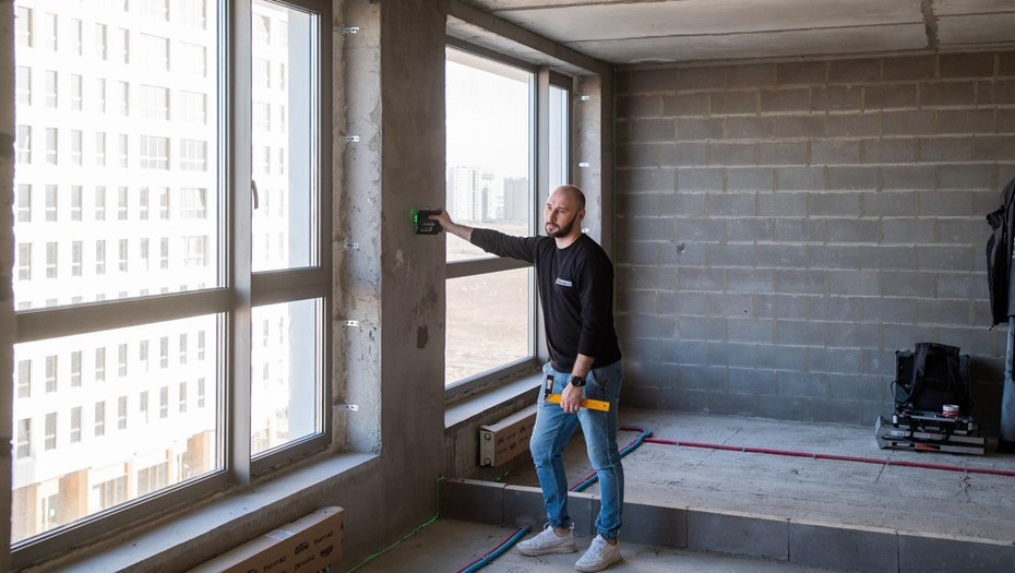 Сотрудник оценочной компании во время осмотра квартиры в новостройке.