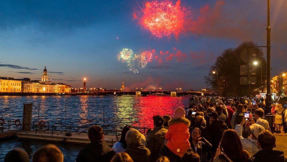 Горожане и гости города наблюдают за салютом в честь Дня Победы на Адмиралтейской набережной.