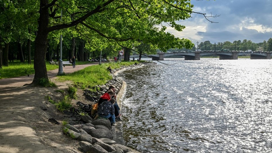 Лопухинский сад. Люди отдыхают на берегу Берег реки Малая Невка в Лопухинском саду.