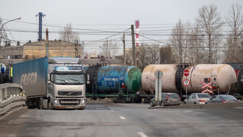 Грузовой автомобиль выезжает из района морского торгового порта на фоне железнодорожный нефтянных цистерн. Грузовой автомобиль выезжает из района морского торгового порта на фоне железнодорожный нефтянных цистерн.